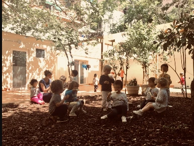 Nens al pati enjardinat i ombrejat de Barcelona Montessori School