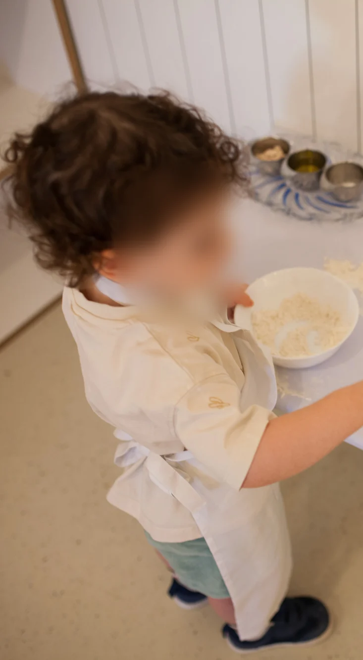 Toddlers in the Nido preparing and sharing their own snack at a low table