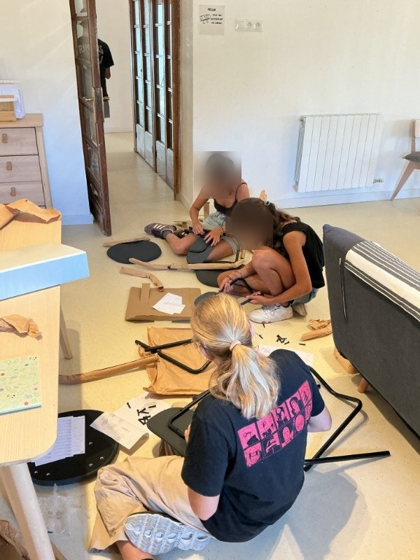Alumnos montando ellos mismos las nuevas sillas y mesas del aula
