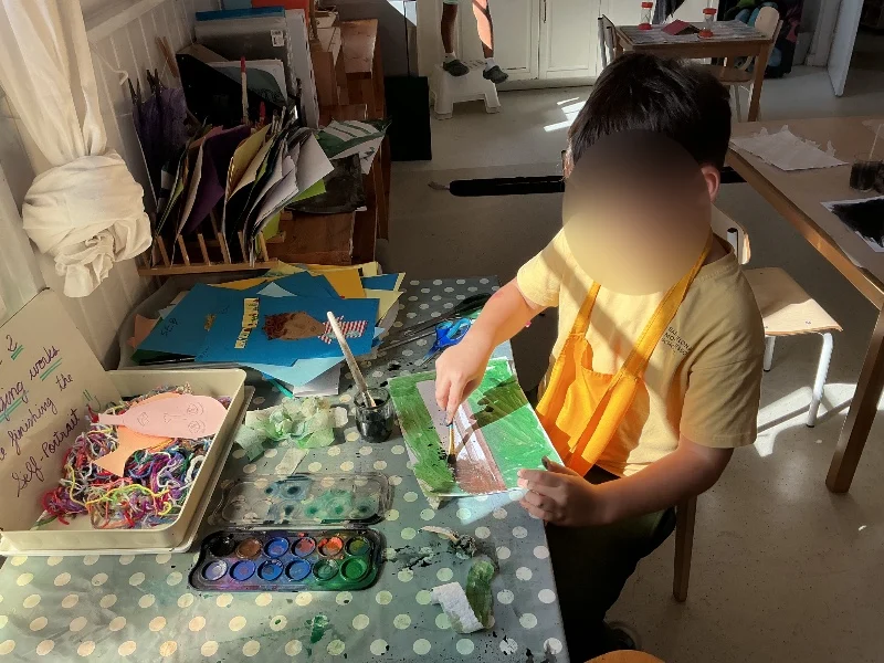Un alumno de primaria pintando con acuarelas en Barcelona Montessori School