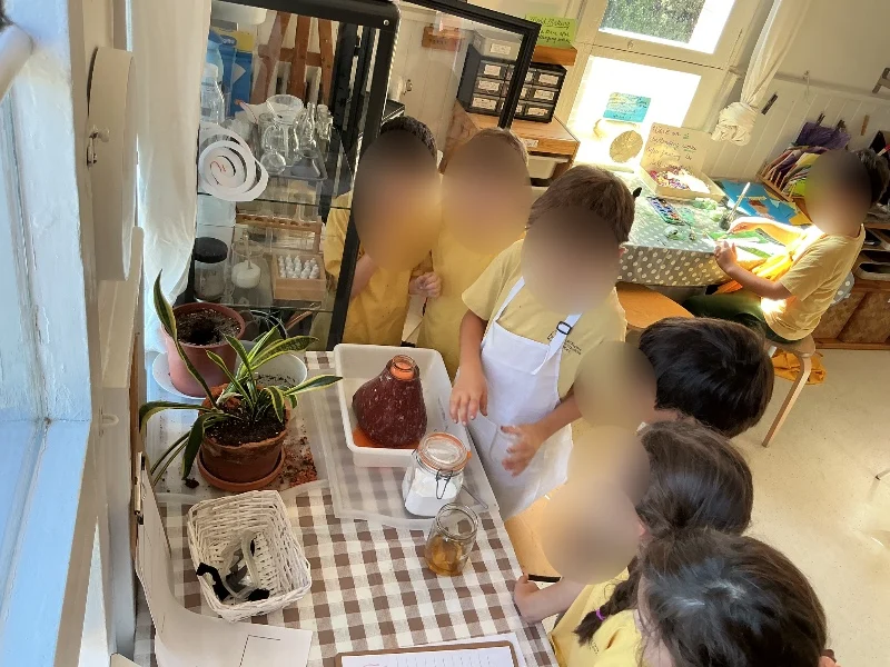 Alumnos de primaria observando de cerca un experimento científico en Barcelona Montessori School